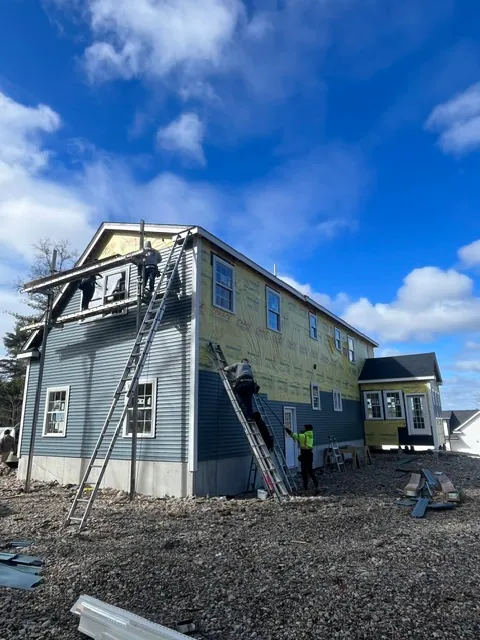 YK United Builders crew installing siding on a Massachusetts home