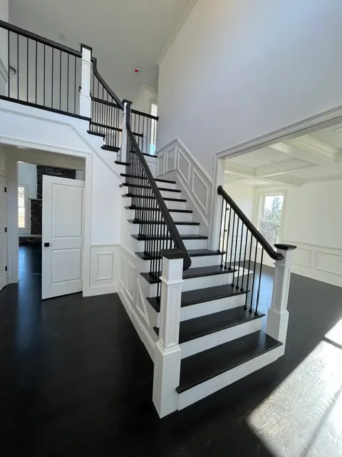 Staircase with wainscoting and coffered ceiling